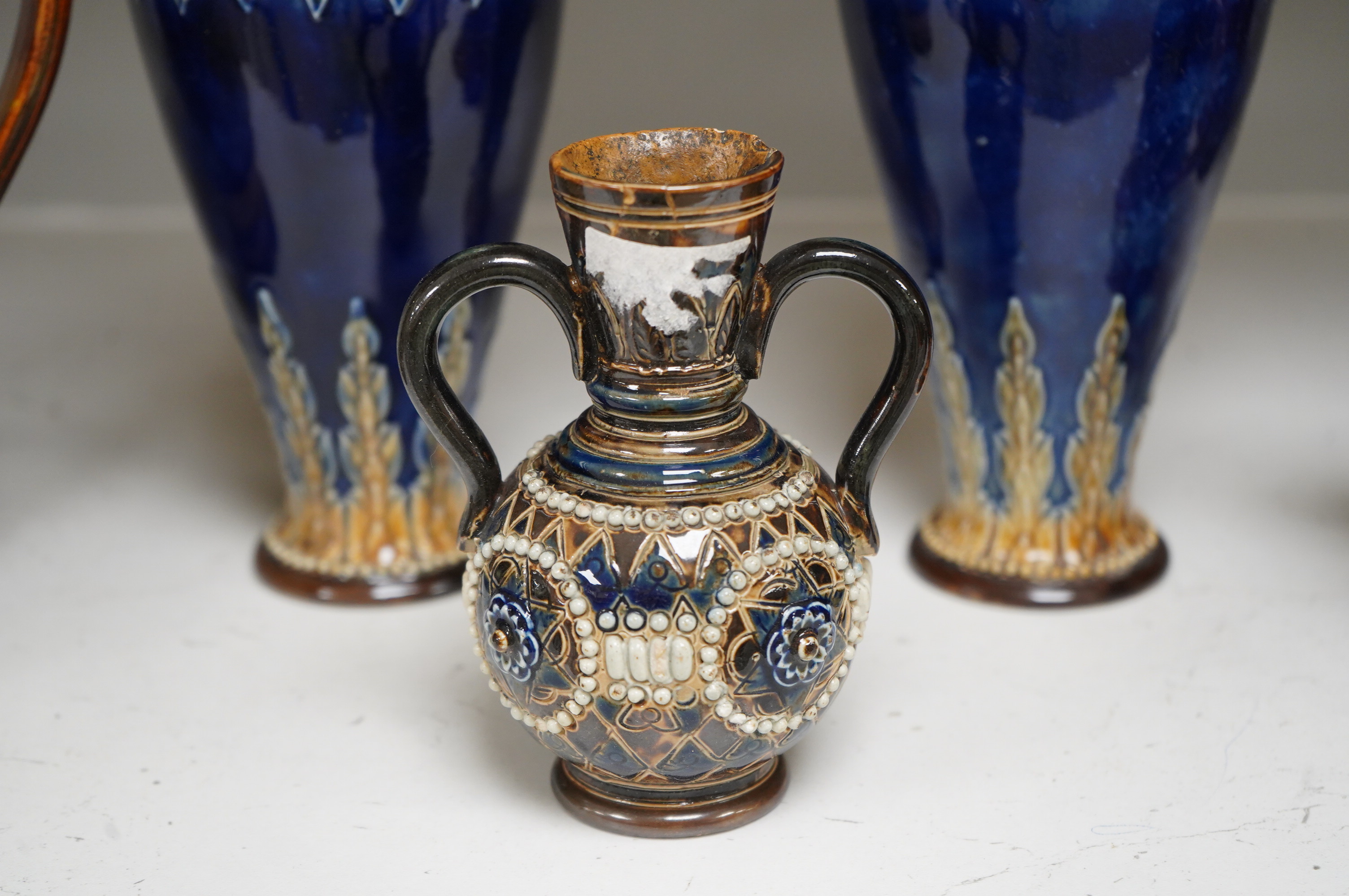 A Doulton Lambeth stoneware commemorative pitcher of William Ewart Gladstone 23cm high, together with a pair of vases two handled vase and a mug, (5).